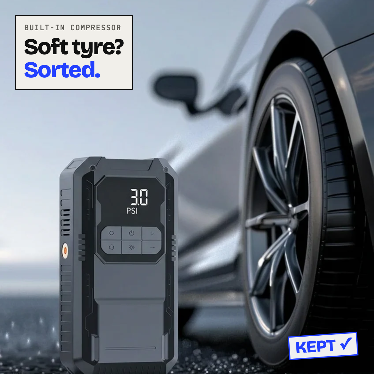 Jump starter with built-in air compressor next to a car tyre