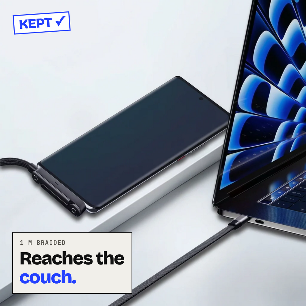 Braided cable charging a phone beside a laptop
